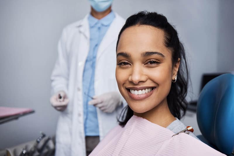 Patient smiling confidently in a dental chair after receiving dental care.